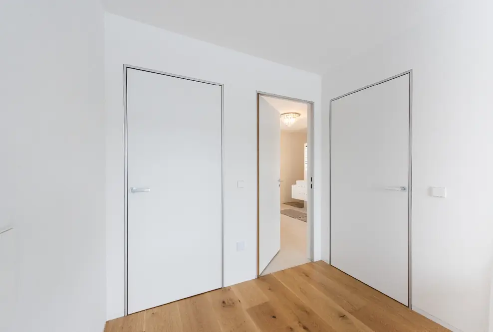 Moderner Minimalismus – wandbündige Türen mit Aluminiumzargen. Schlanke, dezente Zargen passend zum puristischen Architekturstil.