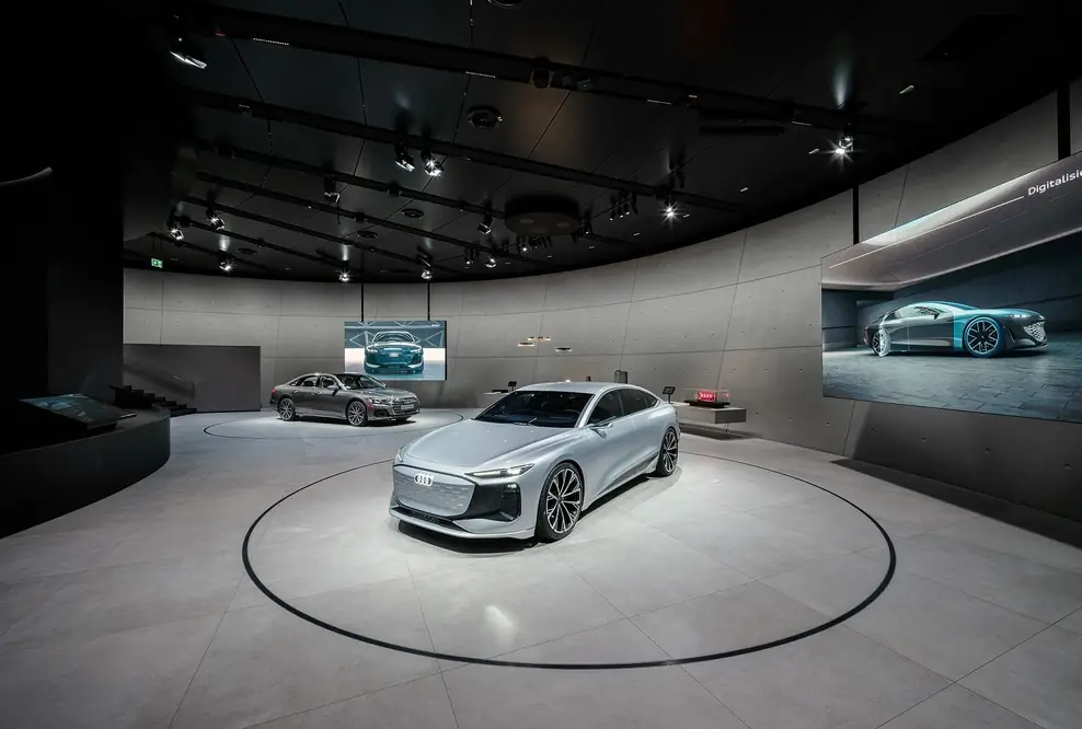 Der Audi A6 e-tron concept und der Plug-in-Hybrid Audi A8 60 TFSI e sowie Exponate auf einem langgestreckten Lowboard erwecken die Themen Digitalisierung und Design zum Leben.
