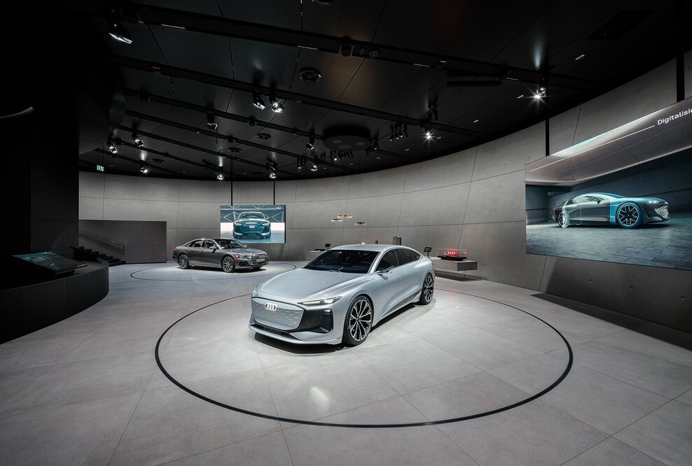 Der Audi A6 e-tron concept und der Plug-in-Hybrid Audi A8 60 TFSI e sowie Exponate auf einem langgestreckten Lowboard erwecken die Themen Digitalisierung und Design zum Leben.
