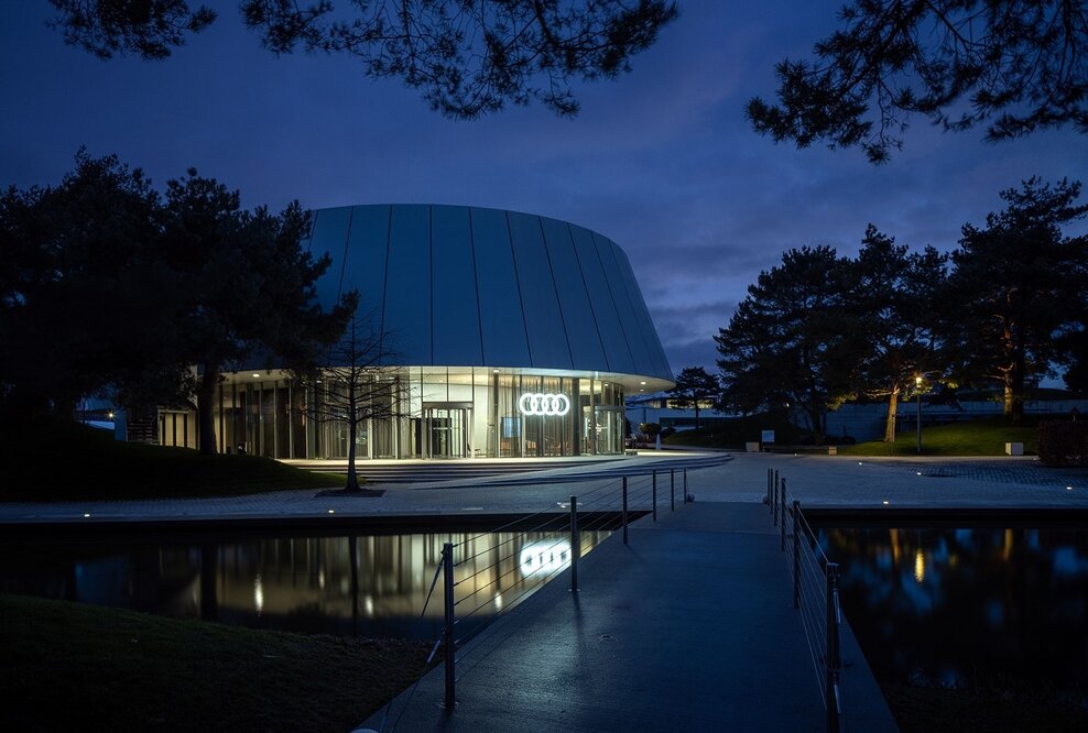 Hinter der zeitlosen Außenarchitektur des Audi Pavillons in der Autostadt Wolfsburg macht Audi die vier Markenwerte Digitalisierung, Design, Performance und Nachhaltigkeit für Besucher_innen erlebbar.