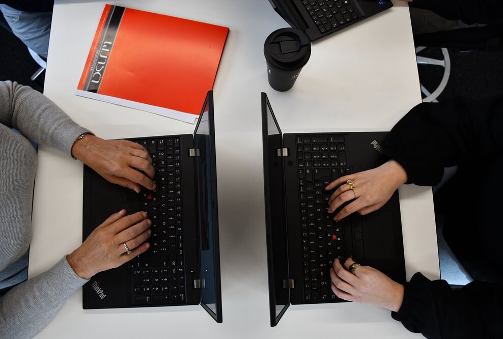 2 Laptops mit tippenden Händen 