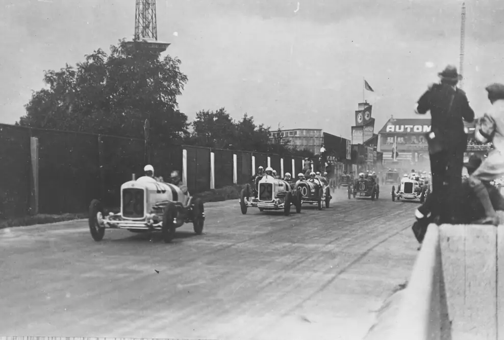 Start zum Großen Preis von Deutschland 1926 auf der AVUS in Berlin. Jakob Scholl (Nr. 28) erwischte mit seinem NSU Sechszylinder-Kompressor den besten Start, gefolgt von der Nr. 29 (Josef Müller). Im Mittelfeld – aber schon auf der Überholspur – Georg Klöble, der dieses Rennen in seiner Klasse gewinnen sollte.
