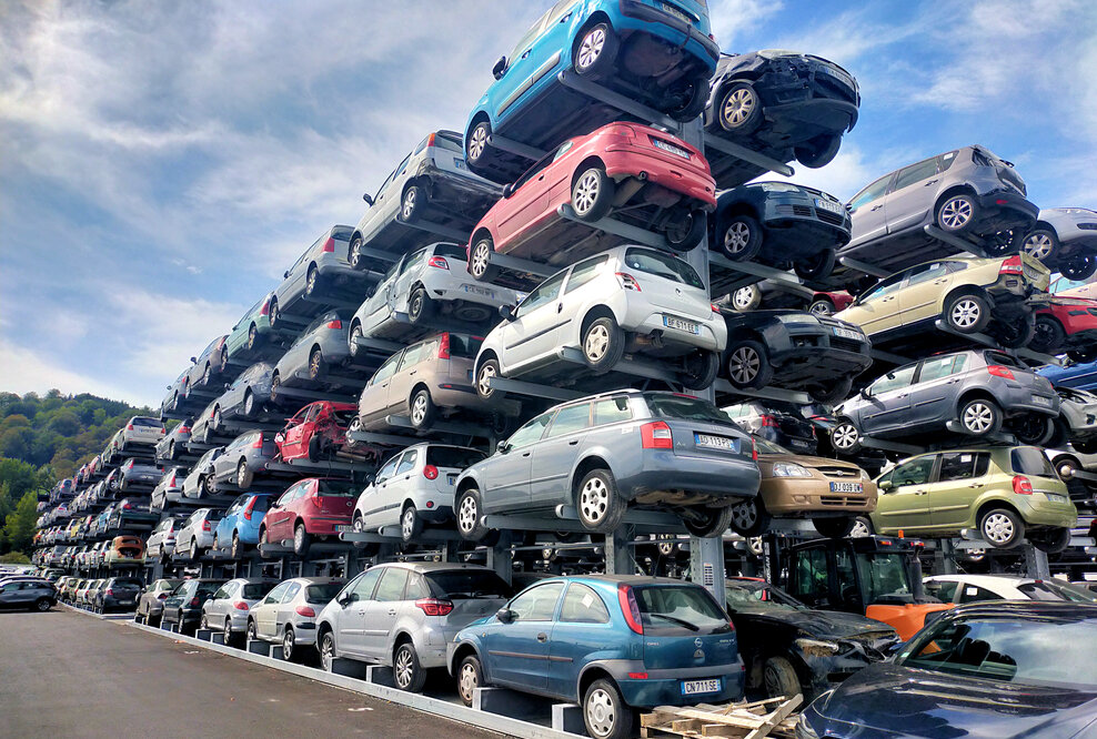 Foto einer Zeil von Kragarmregalen, auf dem in fünf Ebenen Altautos gelagert sind