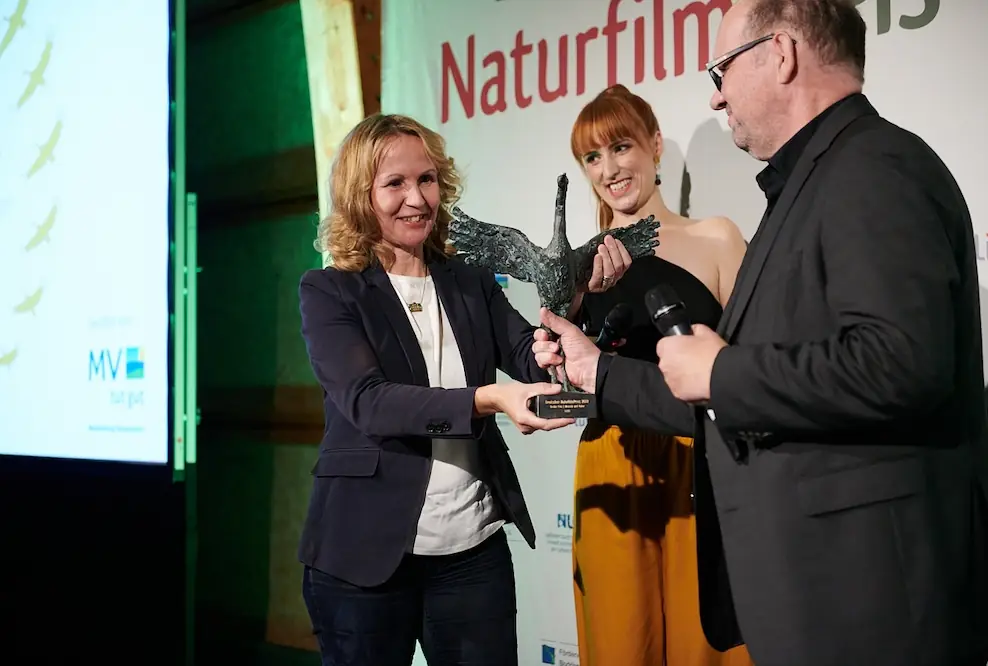 Schirmherrin Steffi Lemke, Bundesministerin für Umwelt, Naturschutz, nukleare Sicherheit und Verbraucherschutz übergibt den "Kranich" an Preisträger Thomas Weidenbach für den Film »Naturwunder Gemüsegarten – Die große Welt der kleinen Tiere« (2022).