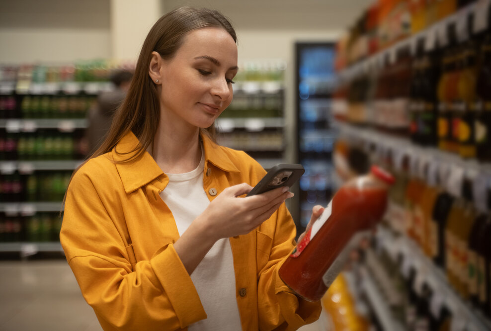 Frau scannt Cashback-Aktion im LEH