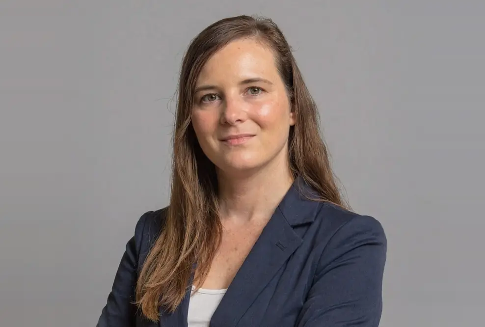 Isabelle Nienhaus, SEO-Expertin und Gründerin von Contenist, in dunkelblauem Blazer vor grauem Hintergrund