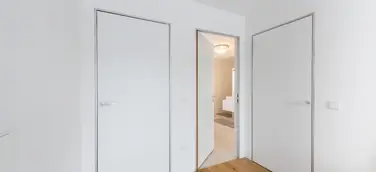 Moderner Minimalismus – wandbündige Türen mit Aluminiumzargen. Schlanke, dezente Zargen passend zum puristischen Architekturstil.