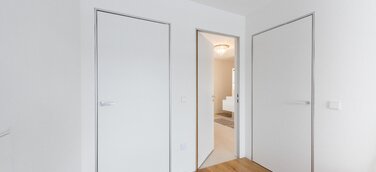 Moderner Minimalismus – wandbündige Türen mit Aluminiumzargen. Schlanke, dezente Zargen passend zum puristischen Architekturstil.