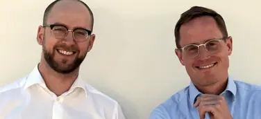 Two men smiling