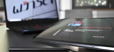 Ein Laptop vor dem ein Tablet liegt.