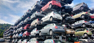Foto einer Zeil von Kragarmregalen, auf dem in fünf Ebenen Altautos gelagert sind
