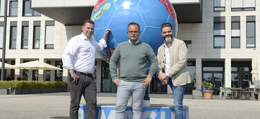 Von links: Stephan Kulbatzki, CFO der Stölting Service Group GmbH, CEO Sebastian Mosbacher und Dr. Boris Westerfeld, COO der Stölting Service Group, vor dem Stahlfußball am Stölting Harbor
