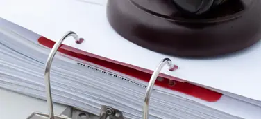 Richterhammer auf einem Aktenordner – Symbol für Bürokratieabbau und neue Regelungen im Vergabetransformationsgesetz.