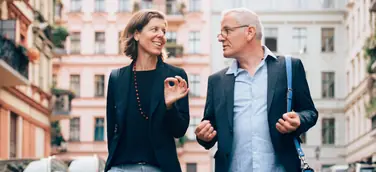 Unternehmerpaar in Unterhaltung über Führungsthemen vertieft, auf dem Weg zu einem Termin
