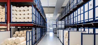 OHRA installierte im Pufferlager von trigema zwischen Herstellung und Ausrüstung Kragarm- und Palettenregale, die eine flexible Zwischenlagerung unterschiedlichster Stoffe ermöglichen. 