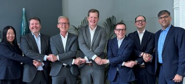 Vertragsunterzeichnung in London mit Frank Lucaßen (medac, Mitte) und Jerome Charton (Clinigen, 3.v.R.)