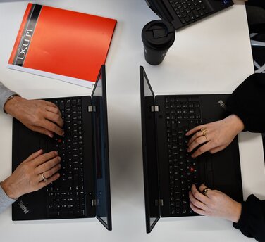 2 Laptops mit tippenden Händen 