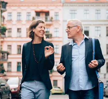 Unternehmerpaar in Unterhaltung über Führungsthemen vertieft, auf dem Weg zu einem Termin
