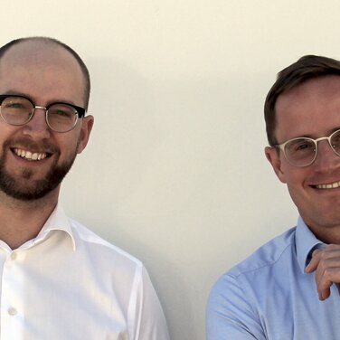 Two men smiling