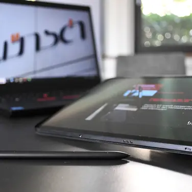 Ein Laptop vor dem ein Tablet liegt.