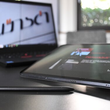 Ein Laptop vor dem ein Tablet liegt.