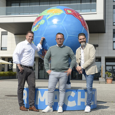 Von links: Stephan Kulbatzki, CFO der Stölting Service Group GmbH, CEO Sebastian Mosbacher und Dr. Boris Westerfeld, COO der Stölting Service Group, vor dem Stahlfußball am Stölting Harbor