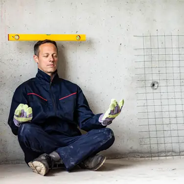 Mann macht ein Art Yogaübung mit Wasserwaage auf dem Kopf