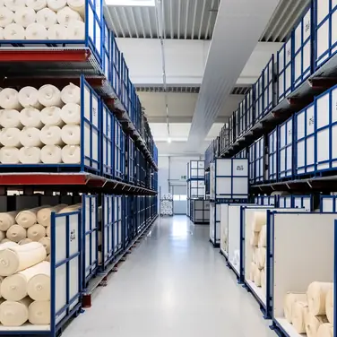 OHRA installierte im Pufferlager von trigema zwischen Herstellung und Ausrüstung Kragarm- und Palettenregale, die eine flexible Zwischenlagerung unterschiedlichster Stoffe ermöglichen. 