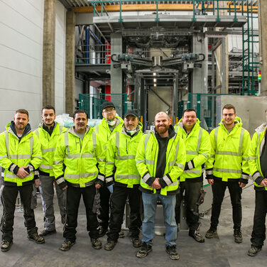 Gruppenbild des Produktionsteams von Dr. Eckel mit der neuen Anlage im Hintergrund