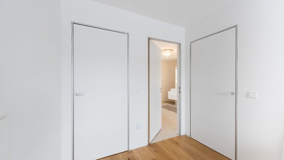 Moderner Minimalismus – wandbündige Türen mit Aluminiumzargen. Schlanke, dezente Zargen passend zum puristischen Architekturstil.