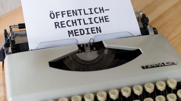 Schreibmaschine mit Papier, auf dem "Öffentlich-Rechtliche Medien" steht.
