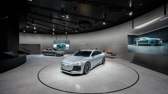 Der Audi A6 e-tron concept und der Plug-in-Hybrid Audi A8 60 TFSI e sowie Exponate auf einem langgestreckten Lowboard erwecken die Themen Digitalisierung und Design zum Leben.