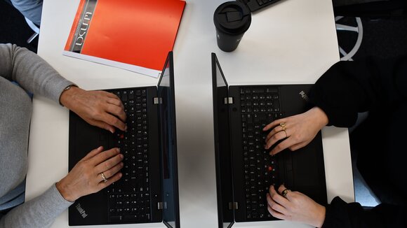 2 Laptops mit tippenden Händen 