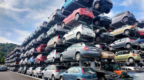 Foto einer Zeil von Kragarmregalen, auf dem in fünf Ebenen Altautos gelagert sind