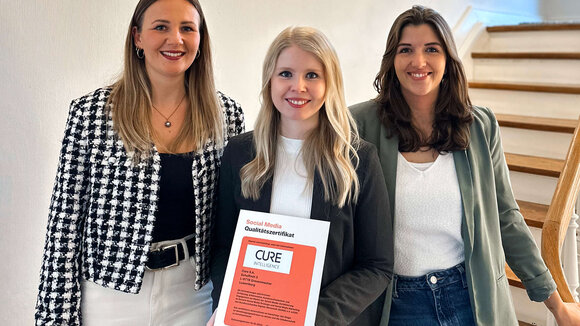 Mitarbeiterinnen aus dem CURE Intelligence Marketing Team sind stolz über die erneute Zertifizierung