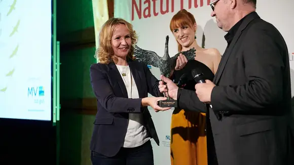 Schirmherrin Steffi Lemke, Bundesministerin für Umwelt, Naturschutz, nukleare Sicherheit und Verbraucherschutz übergibt den "Kranich" an Preisträger Thomas Weidenbach für den Film »Naturwunder Gemüsegarten – Die große Welt der kleinen Tiere« (2022).
