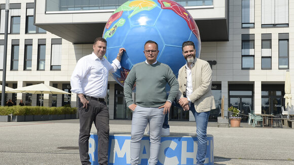 Von links: Stephan Kulbatzki, CFO der Stölting Service Group GmbH, CEO Sebastian Mosbacher und Dr. Boris Westerfeld, COO der Stölting Service Group, vor dem Stahlfußball am Stölting Harbor