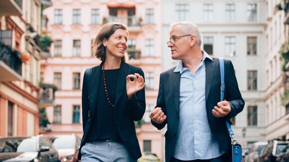 Unternehmerpaar in Unterhaltung über Führungsthemen vertieft, auf dem Weg zu einem Termin