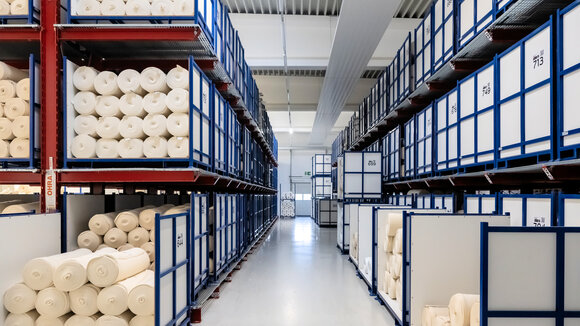 OHRA installierte im Pufferlager von trigema zwischen Herstellung und Ausrüstung Kragarm- und Palettenregale, die eine flexible Zwischenlagerung unterschiedlichster Stoffe ermöglichen. 