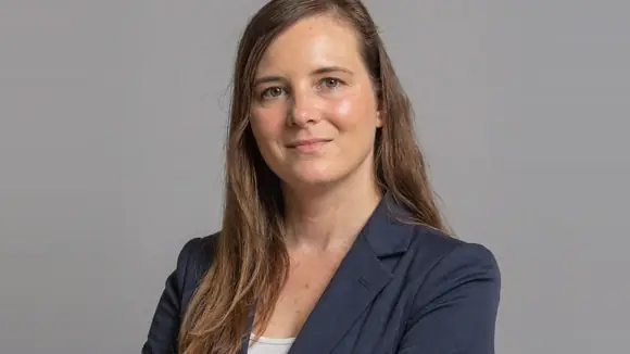 Isabelle Nienhaus, SEO-Expertin und Gründerin von Contenist, in dunkelblauem Blazer vor grauem Hintergrund